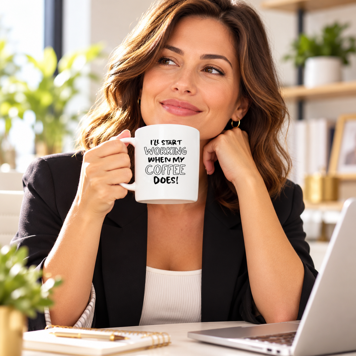 Woman holding I'll Start Working When My Coffee Does mug in an office